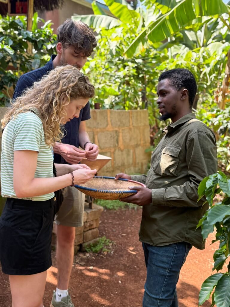 Three people outdoors in a garden exchanging a round woven basket.